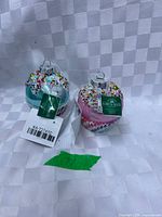 Two cupcake ornaments with tags visible