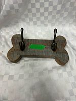 Front view showing dog bone shape and two metal hooks