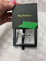 Closed Finn Boutique display case showing branding and earrings inside