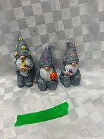 Front view of three gnome figurines