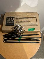 bundle of metal pant hangers beside original Zober box