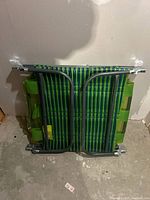 Folded green and blue striped lounge chair against wall