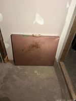 Folded brown metal table leaning against wall