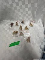 All nine Wade Whimsies figurines individually bagged displayed on checkered backdrop