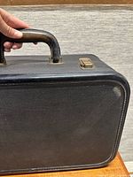 close-up side angle highlighting leather handle and corner wear