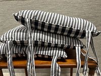 Three cushions stacked showing stripe face and ties