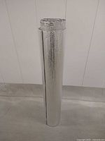Full view of one 48 inch wide reflective foil underlayment roll standing upright