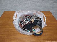 Bag of tangled vintage costume jewelry on table