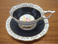 Teacup on saucer showing exterior design and gold accents