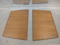 Two teak leaves side by side on floor showing overall size and shape