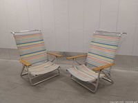 Two folding reclining beach chairs standing upright