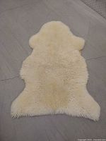 Full view of cream sheepskin rug showing overall size and shape