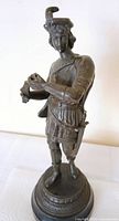 Front view of bronze soldier figure showing overall design and missing object in right hand