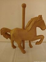 Front left view of unfinished paper mache carousel horse with attached pole