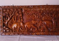 Front view of carved hardwood panel showing elephant jungle scene and glossy finish