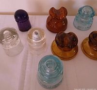 Group shot of all eight glass insulators in various colors and shapes