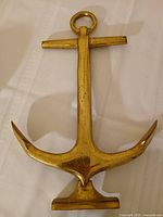 Front view of polished brass anchor andiron