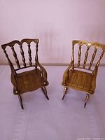Front view of both brass miniature rocking chairs