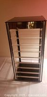 Front view of black acrylic rotating display case with clear bars
