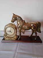Full view of clock and horse on wooden base