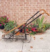 Full side view showing overall construction, wheels, seed hopper, wooden handles