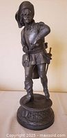 Front view of metal musketeer figurine on pedestal