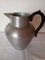 Front view of aluminum pitcher showing spout and handle
