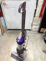 Front view of Dyson DC51 upright vacuum showing cyclone assembly and base