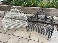 White and black painted metal chicken-wire planters showing overall design, mesh sides, slatted bases and scroll details