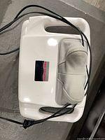 Top view of Pro Shiatsu neck massager showing handles, cushion, and power cord