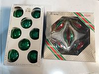 Two boxes of vintage glass Christmas ornaments showing eight green balls and four red/green elongated pieces