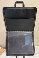 Open binder showing interior pocket and clear sleeves