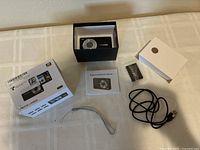 Entire kit with box, camera in inner tray, manual, battery, strap, USB cable