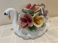 Full view of porcelain swan with floral arrangement on back