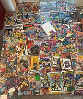 Wide view of entire comic book lot spread on floor showing multiple Wolverine, X-Men, Batman covers