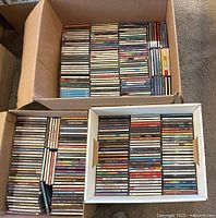 Three cartons filled with rows of CD jewel cases