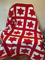 Full view of quilt draped to show overall star pattern and sashing