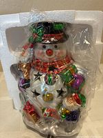 Snowman votive inside plastic wrap seated in styrofoam insert