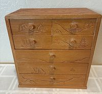 Front view showing carved motifs and seven drawers