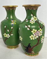 Front view of both green cloisonné vases with blossom and bird design