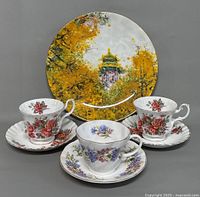 Front view of plate plus three teacup and saucer sets