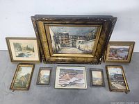 Group shot of all eight framed artworks arranged on floor