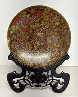Front view of cloisonné plate on stand showing floral design