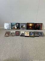 Group shot of all 5 CDs and 8 cassette tapes