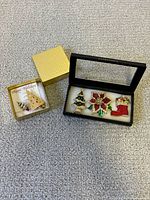 Two boxes showing all five brooches