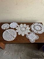 Six crochet doilies displayed on table