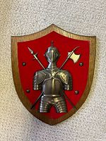 Front of plaque showing knight relief, red felt inset, wood shield
