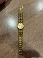 Full view of gold-tone Pierre Cardin wristwatch laid flat