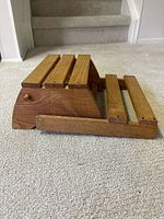 Item folded flat showing side profile of wood slats and hinge mechanism
