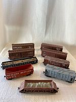 Group shot of eight visible freight cars on white surface